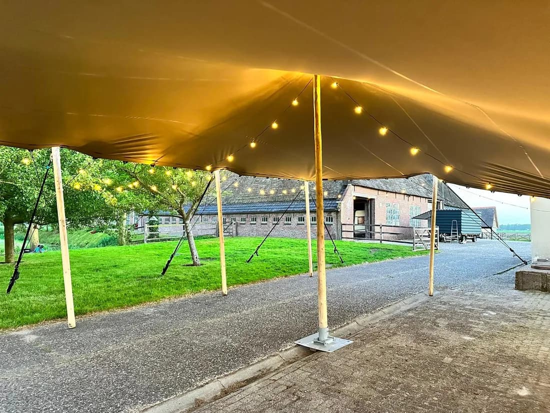 Gouden stretchtent op een grasveld tijdens zonsondergang