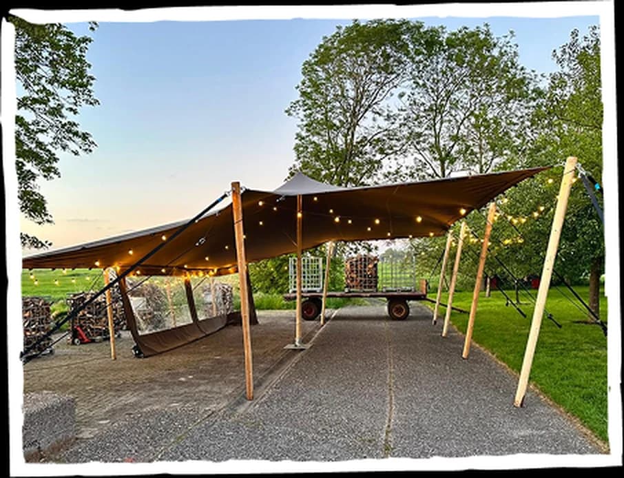 Stretchtent met sfeerverlichting tussen de bomen