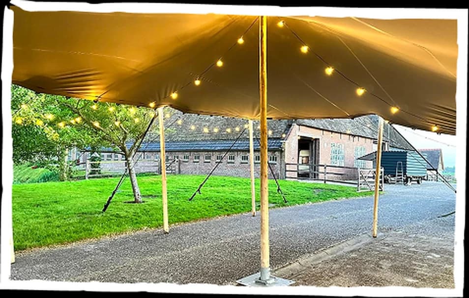 Gouden stretchtent op een grasveld tijdens zonsondergang